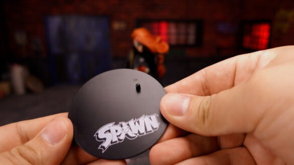 Base circular negra de She-Spawn de McFarlane con el logotipo de Spawn.