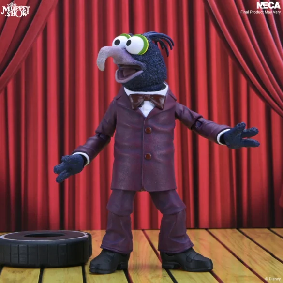 Gonzo de NECA con los brazos abiertos y un neumático sobre el escenario.