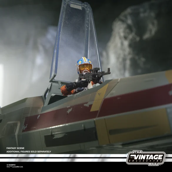 Carson Teva de The Vintage Collection con casco blanco y azul, apuntando desde la cabina de un X-wing.