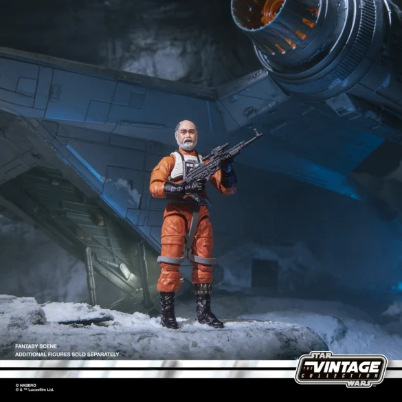 Carson Teva de The Vintage Collection sin casco, con traje naranja y rifle, junto a una nave en un diorama nevado.
