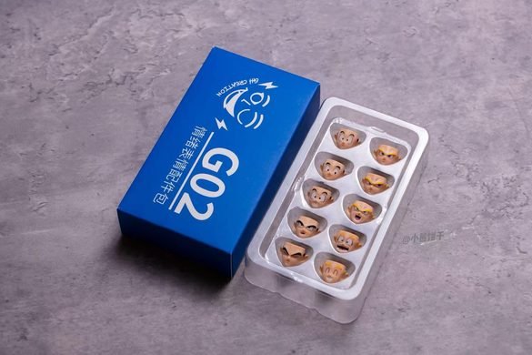 Caja azul G02 de HM Studio con bandeja de rostros alternativos.